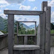 Holzrahmen auf Aussichtsplattform, der den Blick auf ein waldiges Tal und den Donaufluss freigibt.