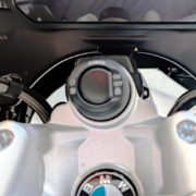 Cockpitblende-mit Silberne BMW Gabelbrücke mit Power-Schalter und Wunderlich-Logo im Hintergrund des Cockpits.