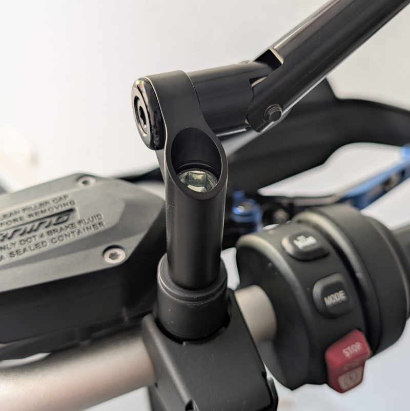 Montierter schwarzer Spiegelarm mit silberner Inbusschraube an einer Motorrad-Lenkerarmatur aus Kunststoff.