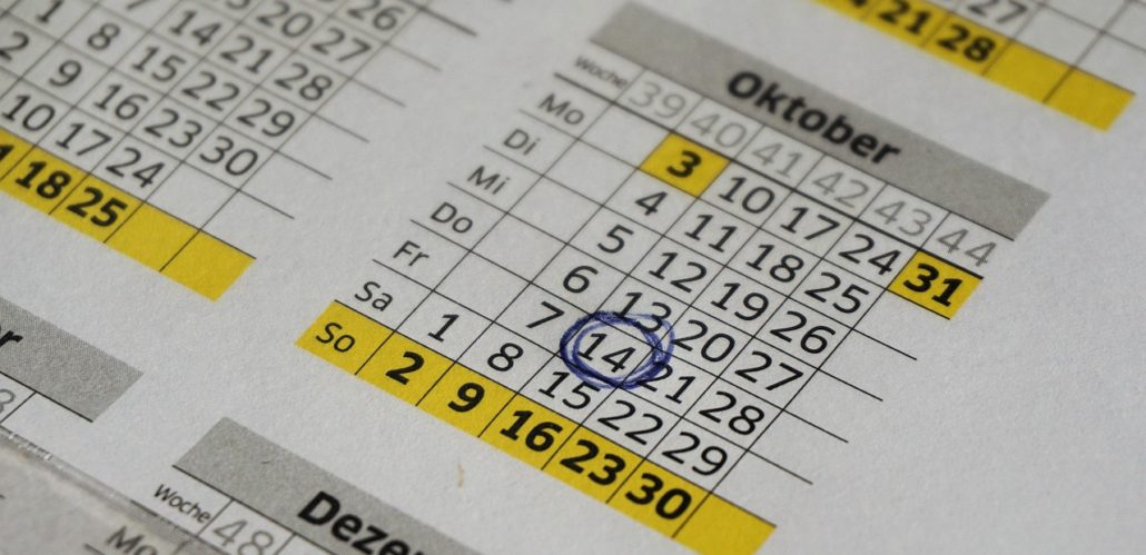 Nahaufnahme eines Papierkalenders mit den Monaten Oktober und November. Der 14. Oktober ist blau eingekreist